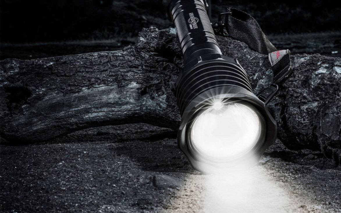 Flashlight on a log with a dark background